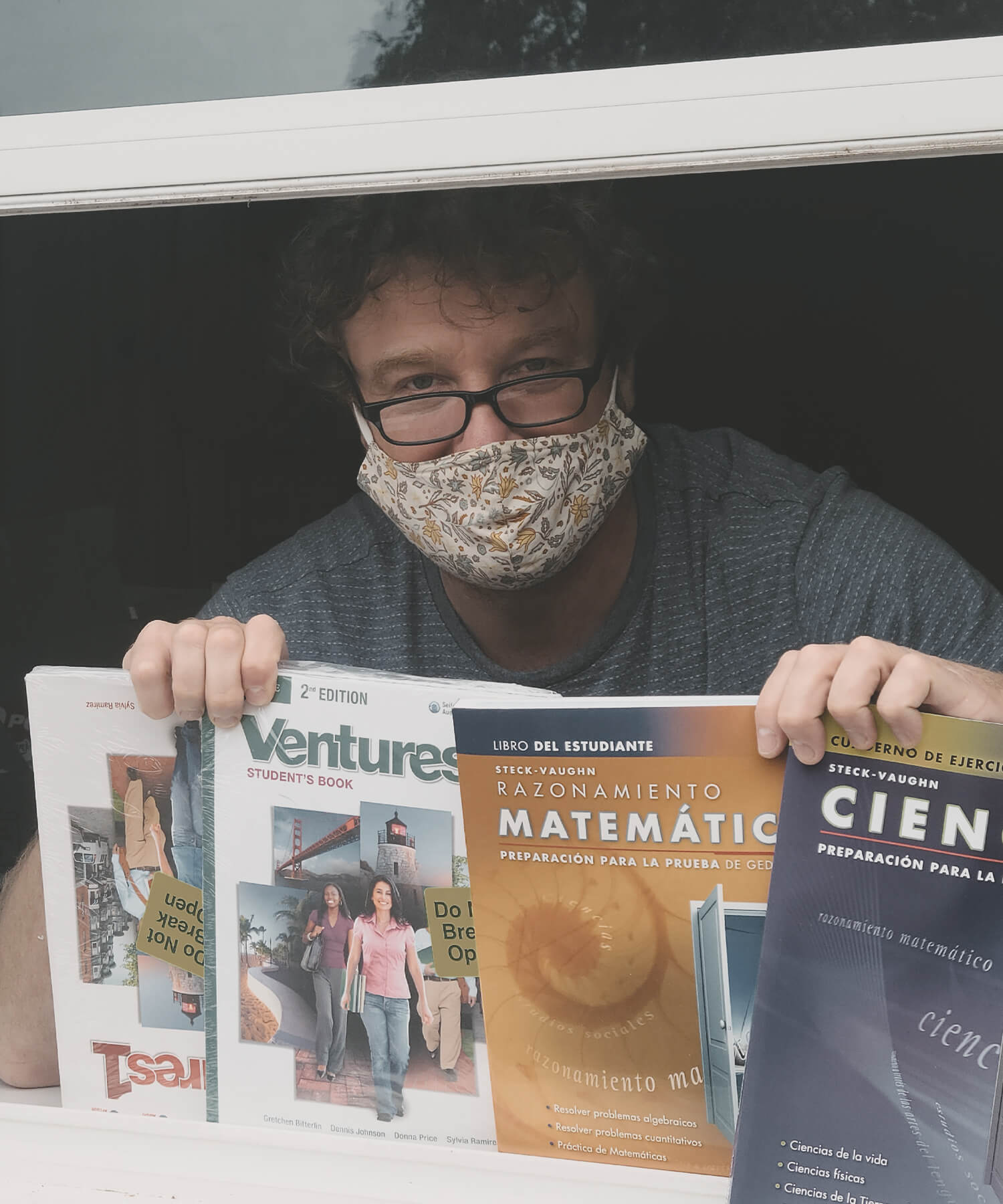 person in mask holding magazines